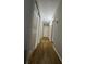 Hallway featuring wood flooring, white doors, and neutral gray walls leading to various rooms at 1649 W Oak Ridge Rd # 1649C, Orlando, FL 32809