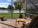 Relaxing screened-in porch with lake views, a lounge chair, and peaceful surroundings at 1820 Trophy Bass Way, Kissimmee, FL 34746