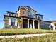 Two-story home featuring stone accents, covered porch with pillars and manicured lawn at 1820 Trophy Bass Way, Kissimmee, FL 34746