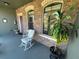 Inviting front porch featuring stone wall, arched windows, and charming rocking chair at 1820 Trophy Bass Way, Kissimmee, FL 34746