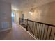 Upstairs hallway with carpet, decorative railing, and chandelier at 1820 Trophy Bass Way, Kissimmee, FL 34746