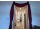 Hallway with decorative curtains leads to a bathroom with a tub and shower at 1820 Trophy Bass Way, Kissimmee, FL 34746