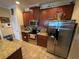 Well-lit kitchen featuring stainless steel appliances, granite countertops, and dark wood cabinets at 1820 Trophy Bass Way, Kissimmee, FL 34746