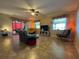 Open living room with tile floors, ceiling fan, and sliding glass doors to the sunroom at 1820 Trophy Bass Way, Kissimmee, FL 34746