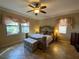 Spacious main bedroom featuring tile floors, a ceiling fan, and two large windows at 1820 Trophy Bass Way, Kissimmee, FL 34746