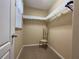 Neutral walk-in closet featuring shelving with decorative trim and a window at 1820 Trophy Bass Way, Kissimmee, FL 34746