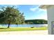Expansive backyard featuring a serene lake view and a large tree, perfect for relaxation at 1966 Derby Glen Dr, Orlando, FL 32837