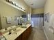 Well-lit bathroom with a double vanity, large mirror, and a shower-tub combination, offering convenience at 1966 Derby Glen Dr, Orlando, FL 32837