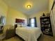 Well-lit bedroom with carpeted floors features a comfortable queen-size bed, and a shelf with books at 1966 Derby Glen Dr, Orlando, FL 32837