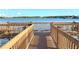 Wooden walkway on a community dock with bench seating overlooking a serene lake at 1966 Derby Glen Dr, Orlando, FL 32837