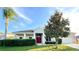 Charming single-story home with a red front door and manicured landscaping in a sunny setting at 1966 Derby Glen Dr, Orlando, FL 32837