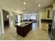 Open concept kitchen with granite island, dark wood cabinets, stainless appliances, and view into living area at 1966 Derby Glen Dr, Orlando, FL 32837
