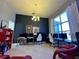 Spacious office with multiple monitors, a chandelier, large windows, and light-colored tile flooring at 1966 Derby Glen Dr, Orlando, FL 32837