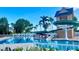 Community pool with water slide, blue water, palm trees, and lounge chairs at 1966 Derby Glen Dr, Orlando, FL 32837