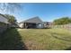 Large backyard featuring a covered patio, grassy area, a storage shed and a wooden fence at 233 River Chase Dr, Orlando, FL 32807