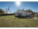 Backyard featuring a storage shed, fire pit, lawn, and various trees and foliage at 233 River Chase Dr, Orlando, FL 32807