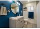 Charming bathroom with sleek vanity, round mirror, and bright blue accent wall at 233 River Chase Dr, Orlando, FL 32807