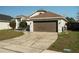 Inviting home exterior with a brown garage door and tidy front lawn at 233 River Chase Dr, Orlando, FL 32807