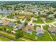 Aerial view of the neighborhood showcasing the lake, mature trees, and nearby houses at 2408 Sweetwater Blvd, St Cloud, FL 34772