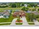 Aerial view of home with mature trees, a two-car garage and a driveway with landscaped island at 2408 Sweetwater Blvd, St Cloud, FL 34772