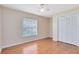 Well-lit bedroom featuring hardwood floors, a window with blinds, and a closet for storage at 2408 Sweetwater Blvd, St Cloud, FL 34772