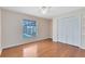 Sunlit bedroom with hardwood floors, a window overlooking the pool area, and a closet for storage at 2408 Sweetwater Blvd, St Cloud, FL 34772