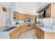 Well-lit kitchen featuring warm wood cabinets, quartz countertops, stainless steel appliances, and tile flooring at 2408 Sweetwater Blvd, St Cloud, FL 34772