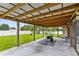 Covered patio with wood beams offers a relaxing outdoor space overlooking the lush backyard at 2408 Sweetwater Blvd, St Cloud, FL 34772