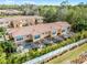 Aerial view of townhomes with screened in patios, tile roofs, and lush landscaping at 2606 Roadster Ln, Kissimmee, FL 34746