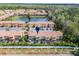 Aerial view of a townhome complex featuring a pond and manicured grounds at 2606 Roadster Ln, Kissimmee, FL 34746