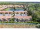 Aerial view of a townhome complex featuring a pond and manicured grounds at 2606 Roadster Ln, Kissimmee, FL 34746