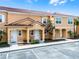 Inviting two-story townhomes with terra cotta tile roofs, covered entrances, and neatly landscaped front yards at 2606 Roadster Ln, Kissimmee, FL 34746