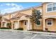 Two-story townhomes with terra cotta tile roofs, covered entrances, and landscaped front yards with parking at 2606 Roadster Ln, Kissimmee, FL 34746