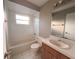 Bright bathroom with a tub and shower, wood vanity, and white tiled flooring at 2801 Christy Ln, St Cloud, FL 34772