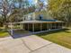 Charming two-story home with a covered carport, screened lanai, and landscaped yard on a sunny day at 2921 Seminole Rd, St Cloud, FL 34772