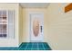 A welcoming front door with an oval window and blue tiled floor, located on a charming covered porch at 2921 Seminole Rd, St Cloud, FL 34772