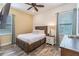 Cozy bedroom with a wood-look tile floor, wooden bed frame, and natural light from the window at 2958 Salted Rim Rd, Kissimmee, FL 34747