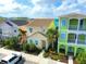 A vibrant two-story home with colorful exterior, complemented by lush landscaping and beautiful tiled roof at 2958 Salted Rim Rd, Kissimmee, FL 34747