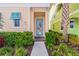 Inviting front entrance with colorful door, brick walkway, and lush tropical landscaping at 2958 Salted Rim Rd, Kissimmee, FL 34747