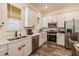 Modern kitchen featuring white cabinets, stainless steel appliances, and wood-look tile floors at 2958 Salted Rim Rd, Kissimmee, FL 34747