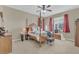 Bedroom featuring a four poster bed with an assortment of pillows and bright red curtains on the windows at 3050 Grasmere View Pkwy, Kissimmee, FL 34746