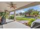 View of the backyard from the covered patio showing the surrounding landscape with a ceiling fan overhead at 3050 Grasmere View Pkwy, Kissimmee, FL 34746