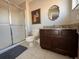 The bathroom features a glass shower, dark wood vanity, and decorative mirror at 3136 Yellow Lantana Ln, Kissimmee, FL 34747