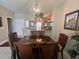 Dining room with wooden table set and chandelier, overlooking the open kitchen at 3136 Yellow Lantana Ln, Kissimmee, FL 34747