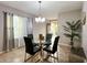 Bright dining room features a glass-topped table set for four, neutral paint, and modern chandelier at 3211 Surfbird St, Kissimmee, FL 34744