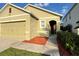 Close up of a charming single-Gathering home featuring a well-manicured lawn with a two-car garage at 3211 Surfbird St, Kissimmee, FL 34744