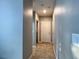 Hallway with tiled floor leading to a white paneled door and rooms at 3211 Surfbird St, Kissimmee, FL 34744