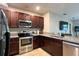 This modern kitchen features stainless steel appliances, granite countertops, and dark wood cabinetry at 3211 Surfbird St, Kissimmee, FL 34744