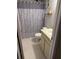 Bathroom with gray tiled floors and shower curtain with leaf design and a light vanity at 3240 S Semoran Blvd # 14, Orlando, FL 32822