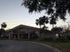 Community clubhouse featuring a large social hall and beautifully landscaped grounds with mature palm trees at 3240 S Semoran Blvd # 14, Orlando, FL 32822